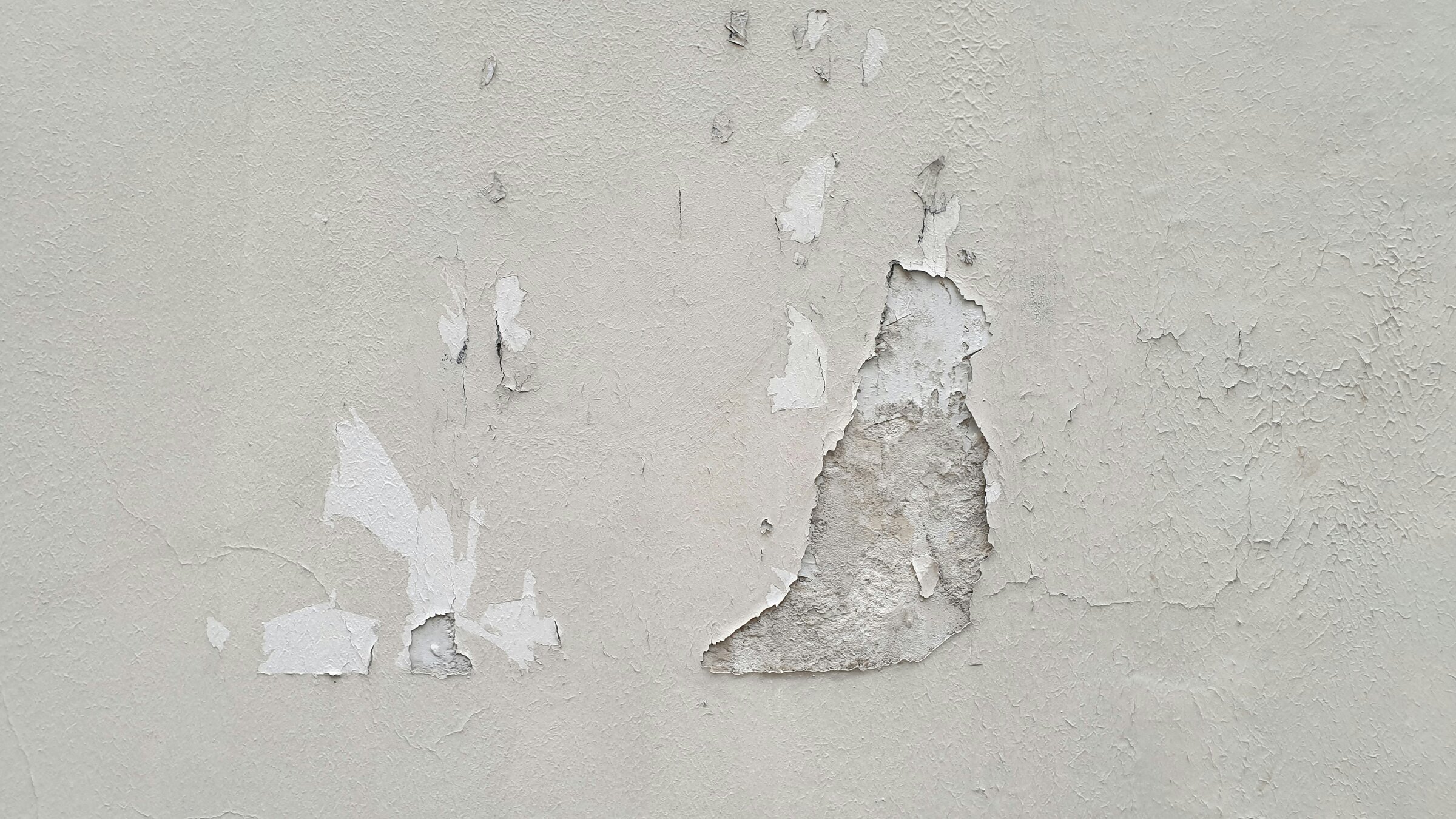 Afbladderende verf op een betonnen muur